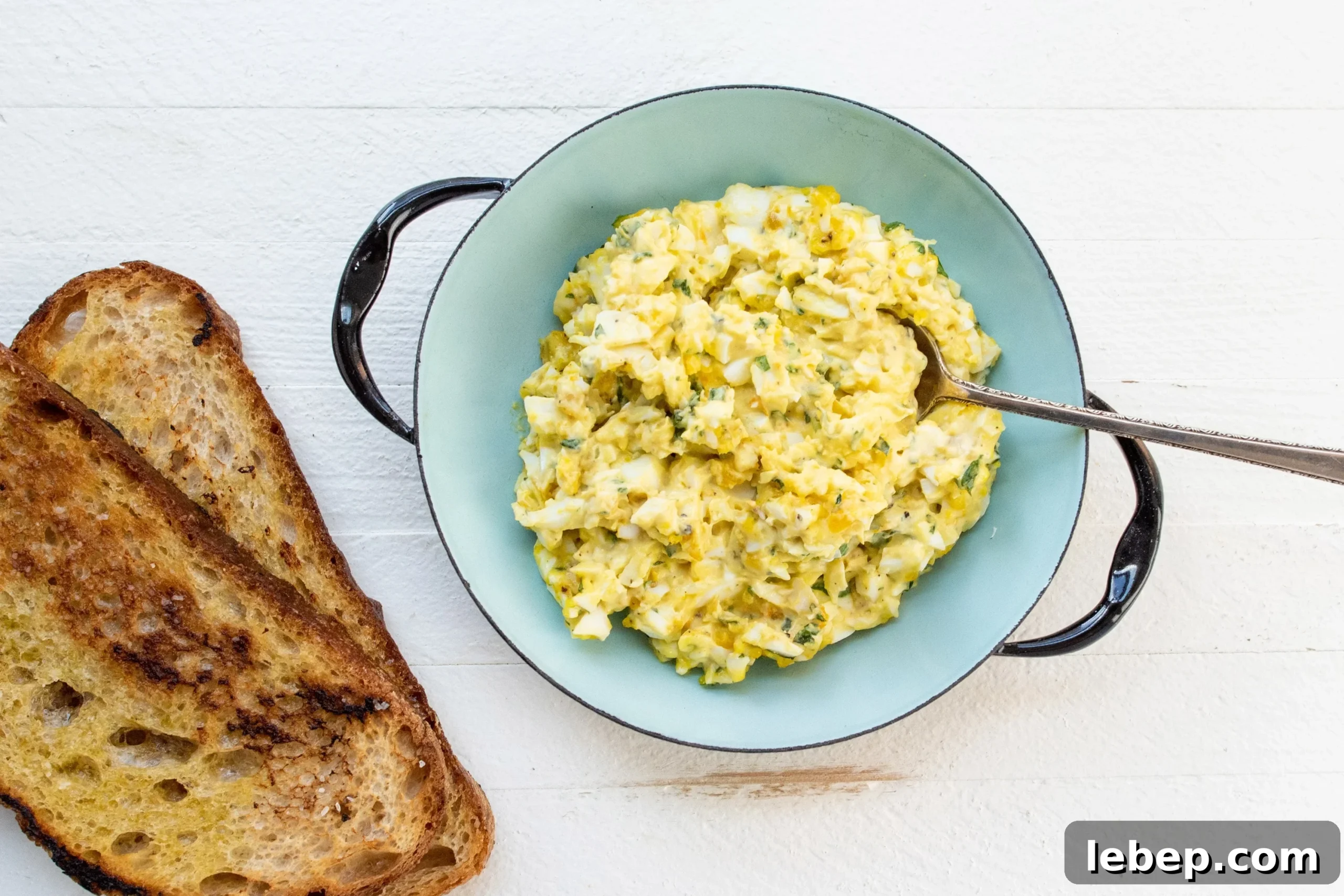 Cooking with Basil: 12 Flavorful Ways to Use Fresh Basil in Meals 11 Egg Salad in a blue bowl with toast next to it.