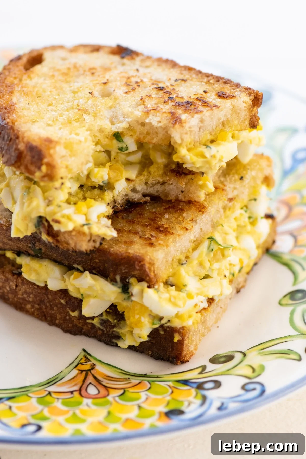 Cooking with Basil: 12 Flavorful Ways to Use Fresh Basil in Meals 12 An egg salad sandwich with a bite taken out of it.