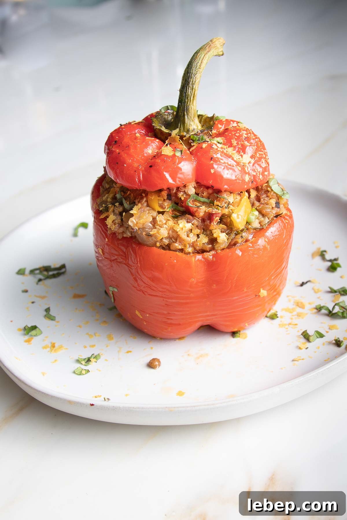 Vegan Lentil-Stuffed Peppers Recipe: Hearty Plant-Based Dinner 2 Red bell pepper stuffed with quinoa lentil mixture with the top back on.