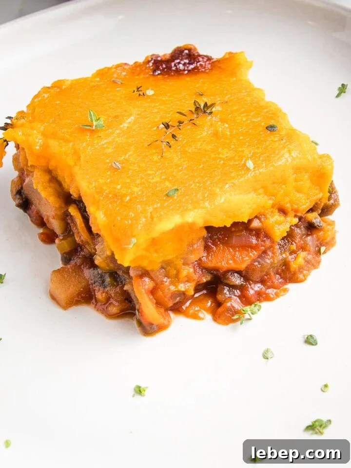 close up of a piece of veggie shepherd's pie on a white rimmed plate.