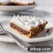 Chocolate Haupia Pie Recipe — Creamy Hawaiian Coconut Dessert 4 A slice of chocolate haupia pie on a white plate with a silver spoon.