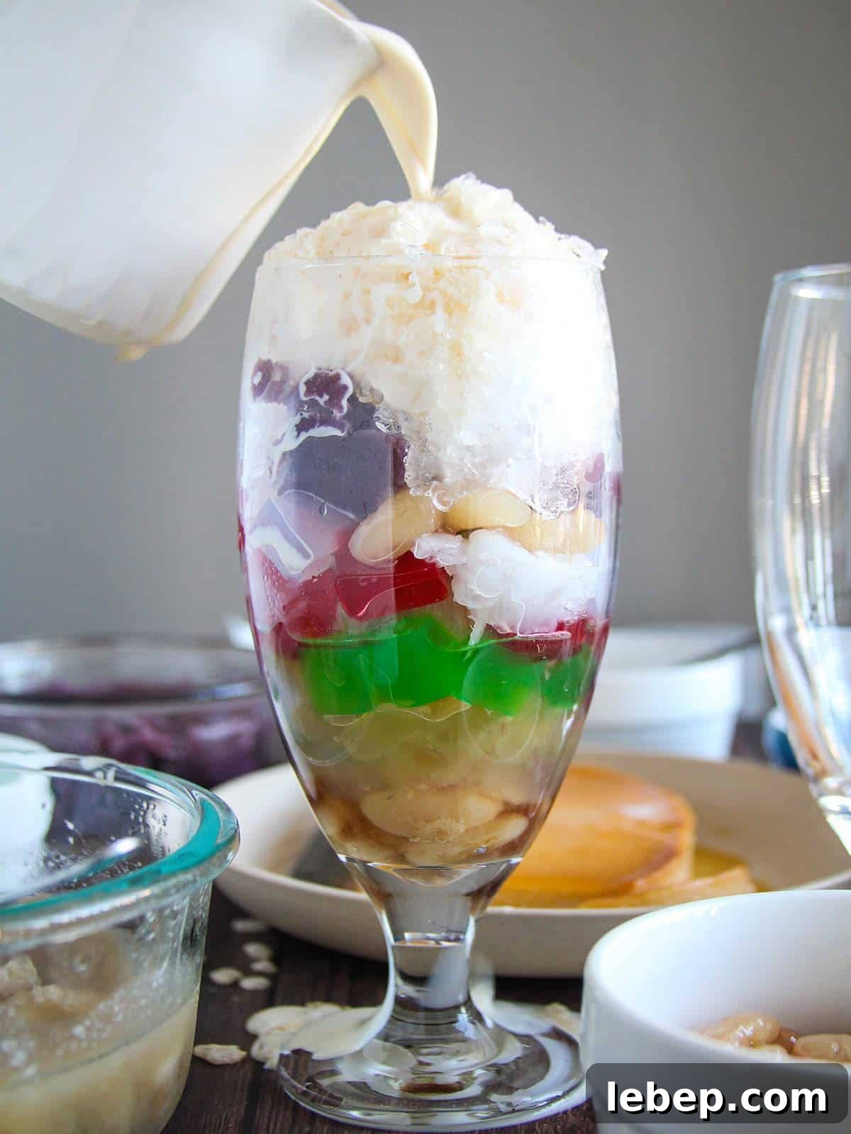 Halo-Halo: The Filipino Dessert Guide to Layers, Ingredients & Tips 7 pouring evaporated milk in a glass of halo-halo