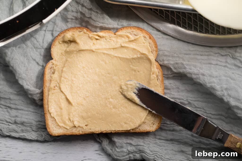 Hummus and Melted Cheese Toastie Recipe for Quick Lunch 4 hummus spread on a piece of wheat bread