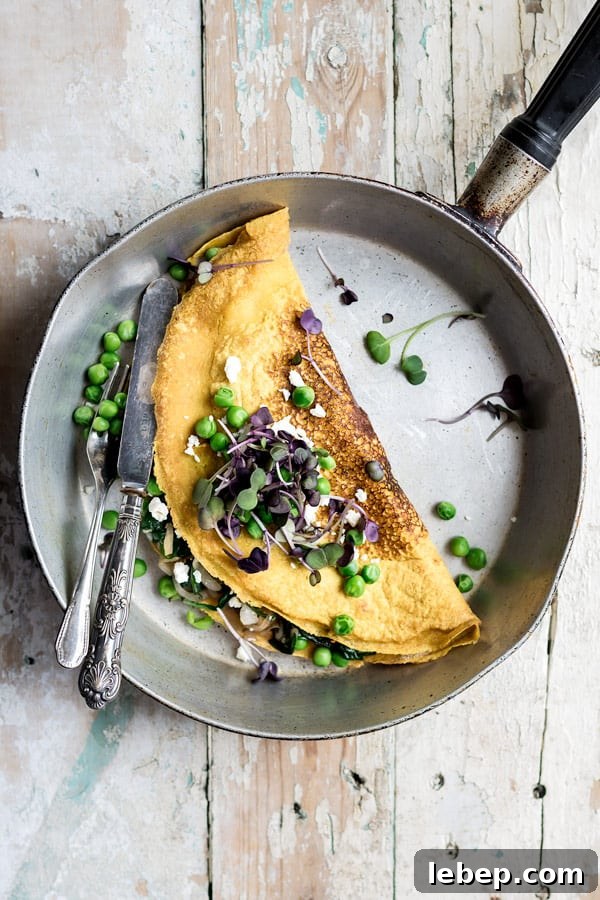 vegan and gluten free omelette made with chickpeas in skillet with knife and fork