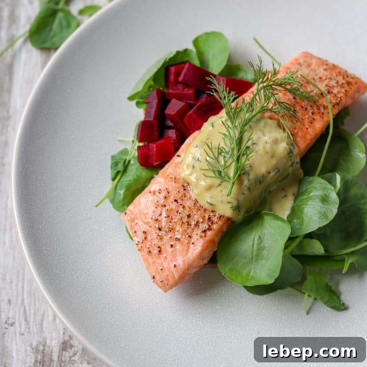 Salmon with mustard sauce, pickled beets and salad on a plate