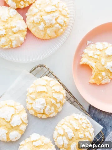 Lemon crinkle cookies on a cooling rack with some transferred to pink plates.