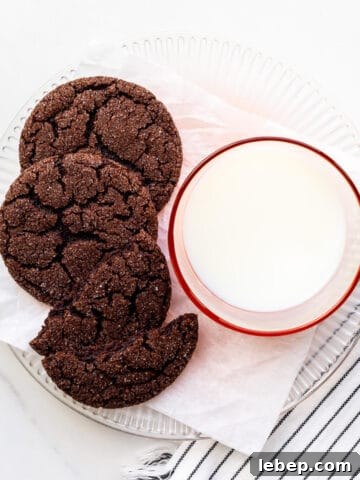 A plate of chocolate sugar cookies and a glass of milk.