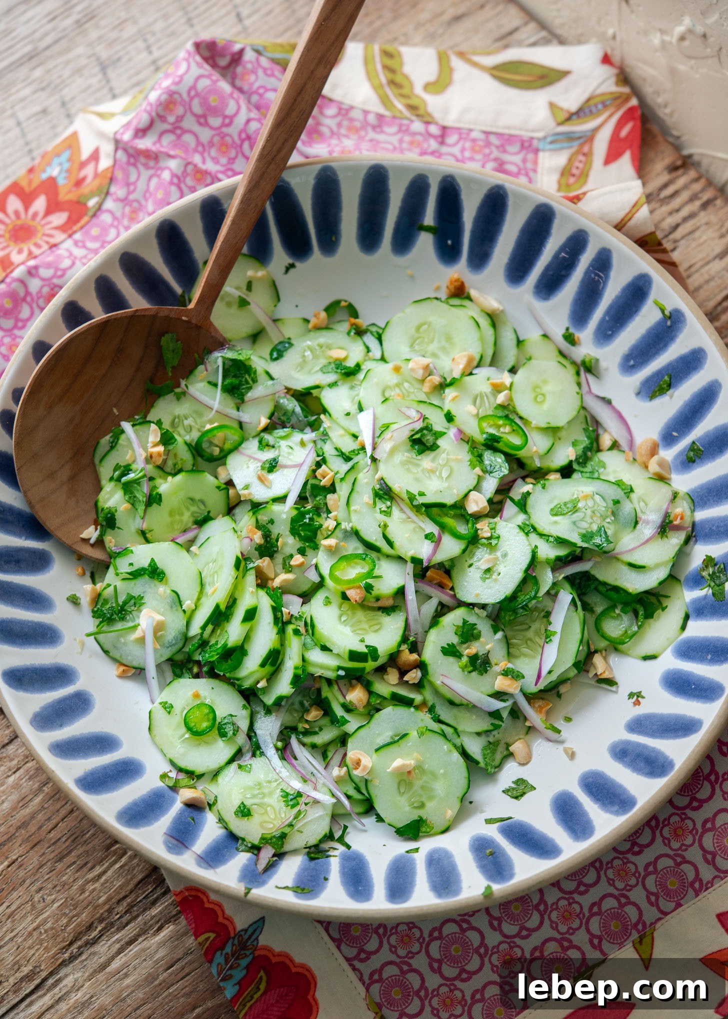 Vietnamese cucumber salad in a serving dish with wooden spoon.