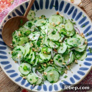 Vietnamese cucumber salad in a serving dish with wooden spoon.