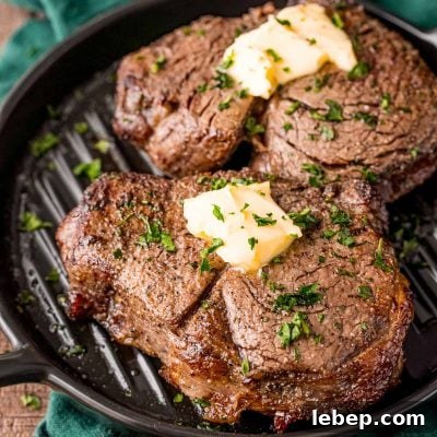 Perfect Air Fryer Filet Mignon Recipe for Tender Steak 7 Two steaks on a black plate on a green napkin.