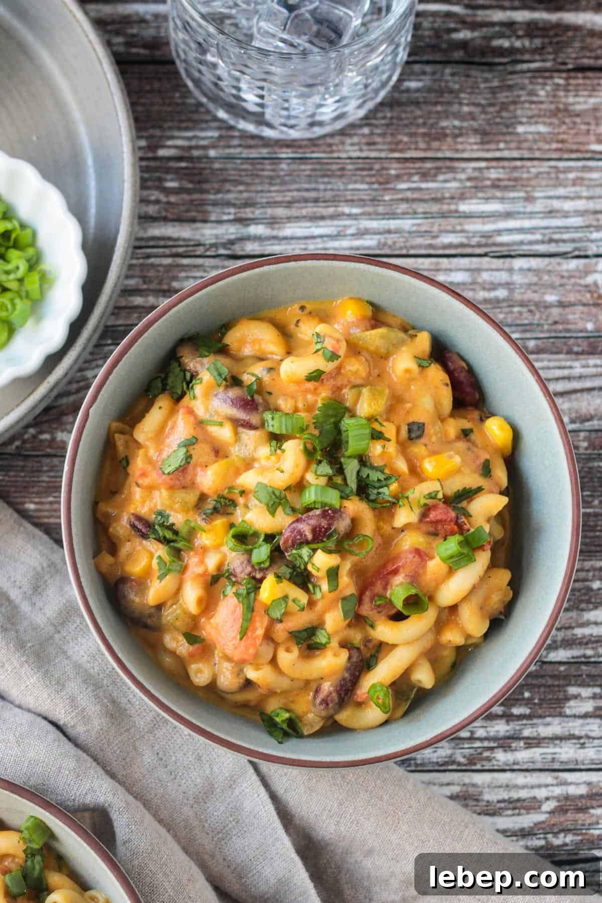 Bowl of vegan chili mac with kidney beans topped with chopped fresh cilantro.
