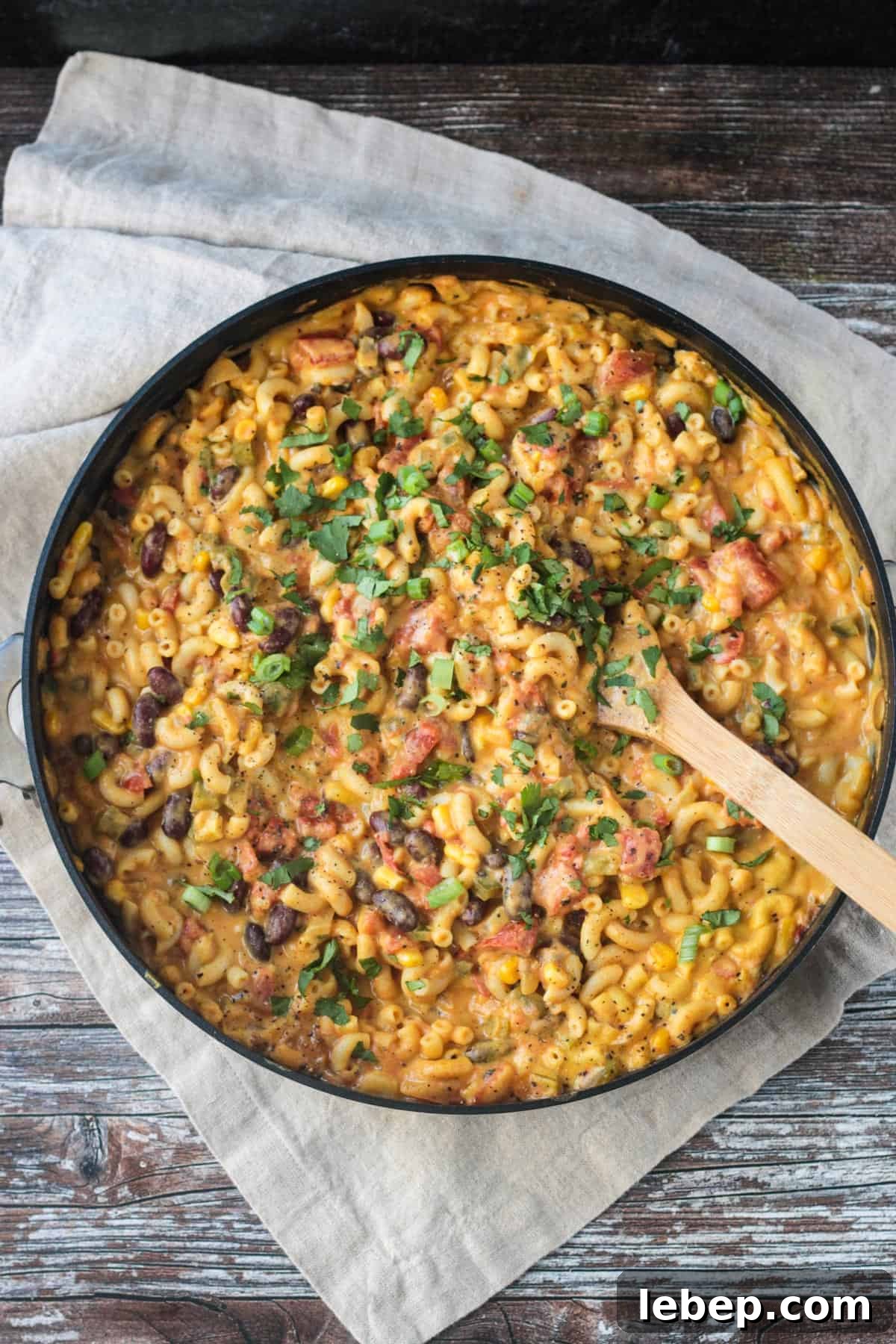 Finished dish in a skillet with a wooden spoon.