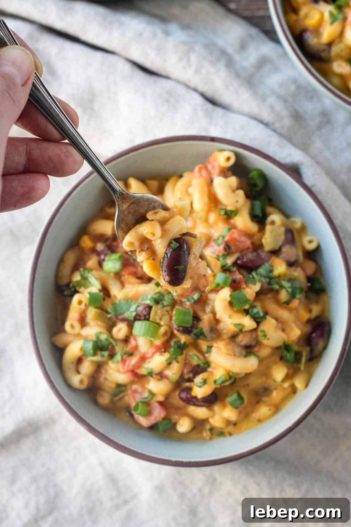 One bite of food on a fork being lifted from a bowl.