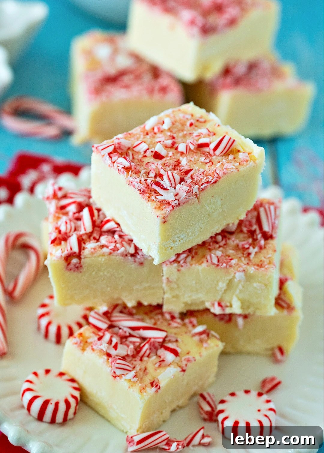 Peppermint White Chocolate Fudge stacked up on a plate.
