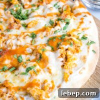 Buffalo Chicken Pizza Recipe: Spicy Wing Flavor on Crispy Crust 2 Close up of the edge of a buffalo chicken pizza topped with parsley