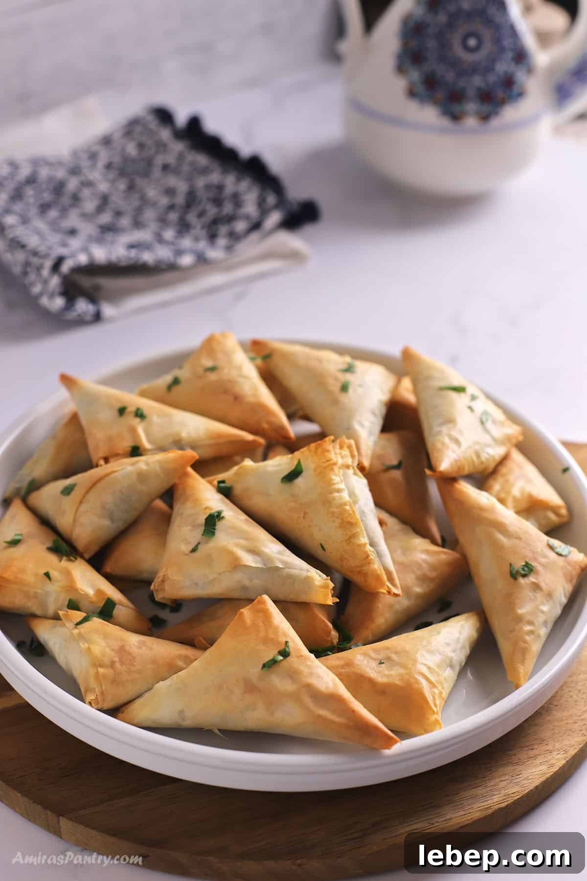 A pile of spanakopita triangles on a platter.