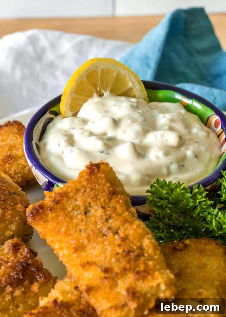 Classic Creamy Tartar Sauce Recipe for Fish and Seafood 3 closeup side view: creamy tartar sauce in bowl next to breaded fish sticks