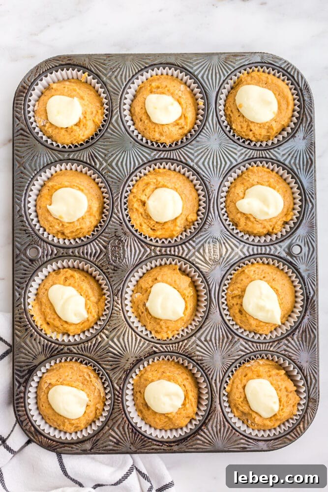 Fluffy Pumpkin Muffins with Cream Cheese Swirl 15 picture of muffins and cream cheese piped on top
