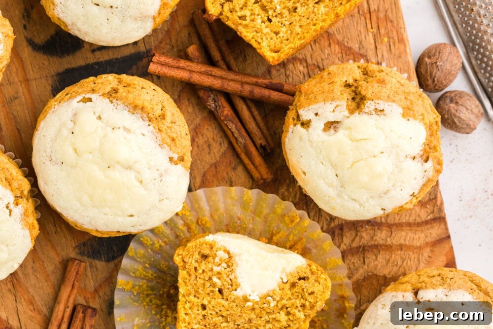 Fluffy Pumpkin Muffins with Cream Cheese Swirl 4 picture of pumpkin cream cheese muffin in a paper wrapper