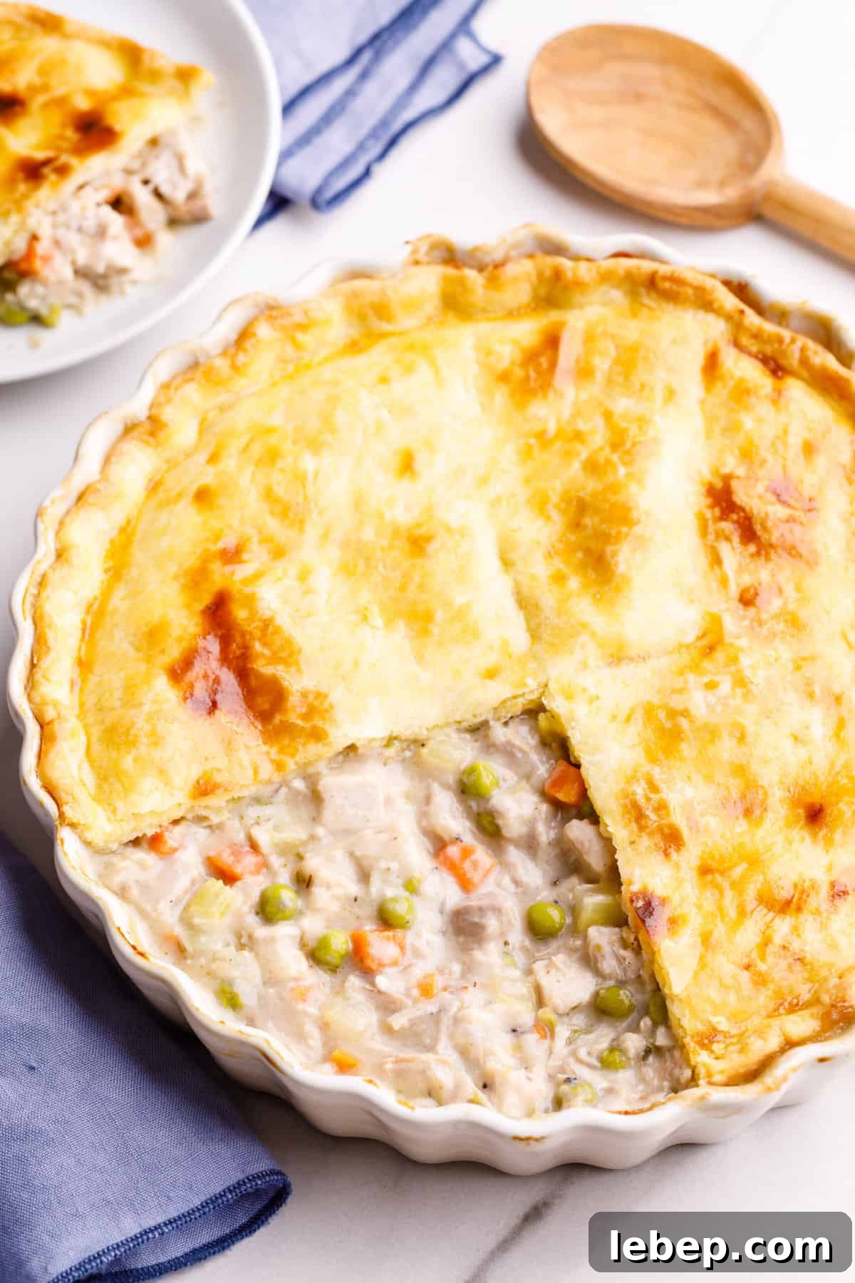 Comfortable Turkey Pot Pie Recipe with Flaky Crust 3 top down image of turkey pot pie with a quarter of the pie crust removed to show the inside of the pie