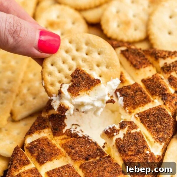 Smoked Baked Potatoes Recipe: Crispy Skin, Smoky Flavor 11 A hand dipping crackers into a cream cheese dip.