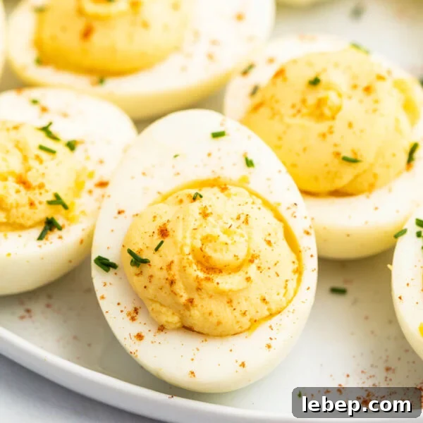 Smoked Baked Potatoes Recipe: Crispy Skin, Smoky Flavor 13 Creamy deviled eggs garnished with paprika and chives on a white plate