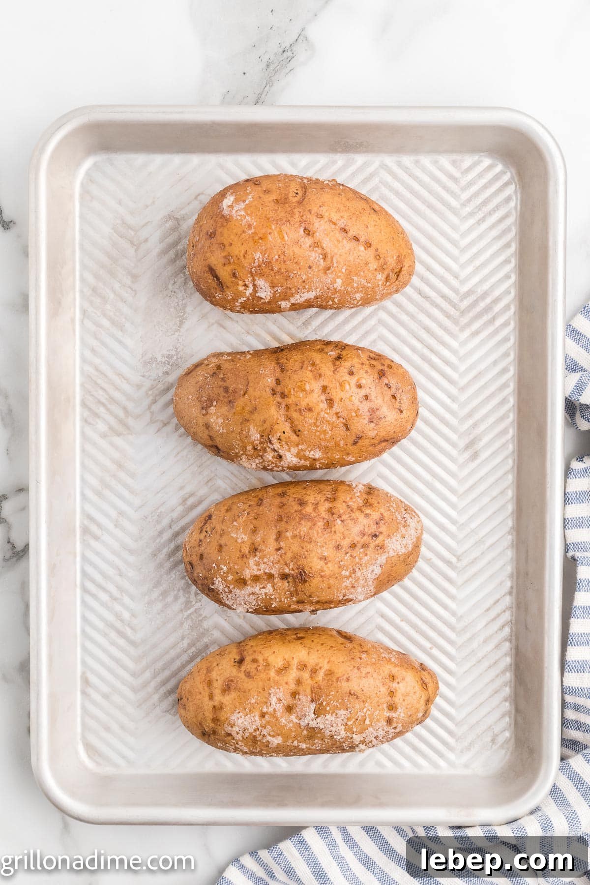 Smoked Baked Potatoes Recipe: Crispy Skin, Smoky Flavor 4 Baked Potatoes on a baking sheet