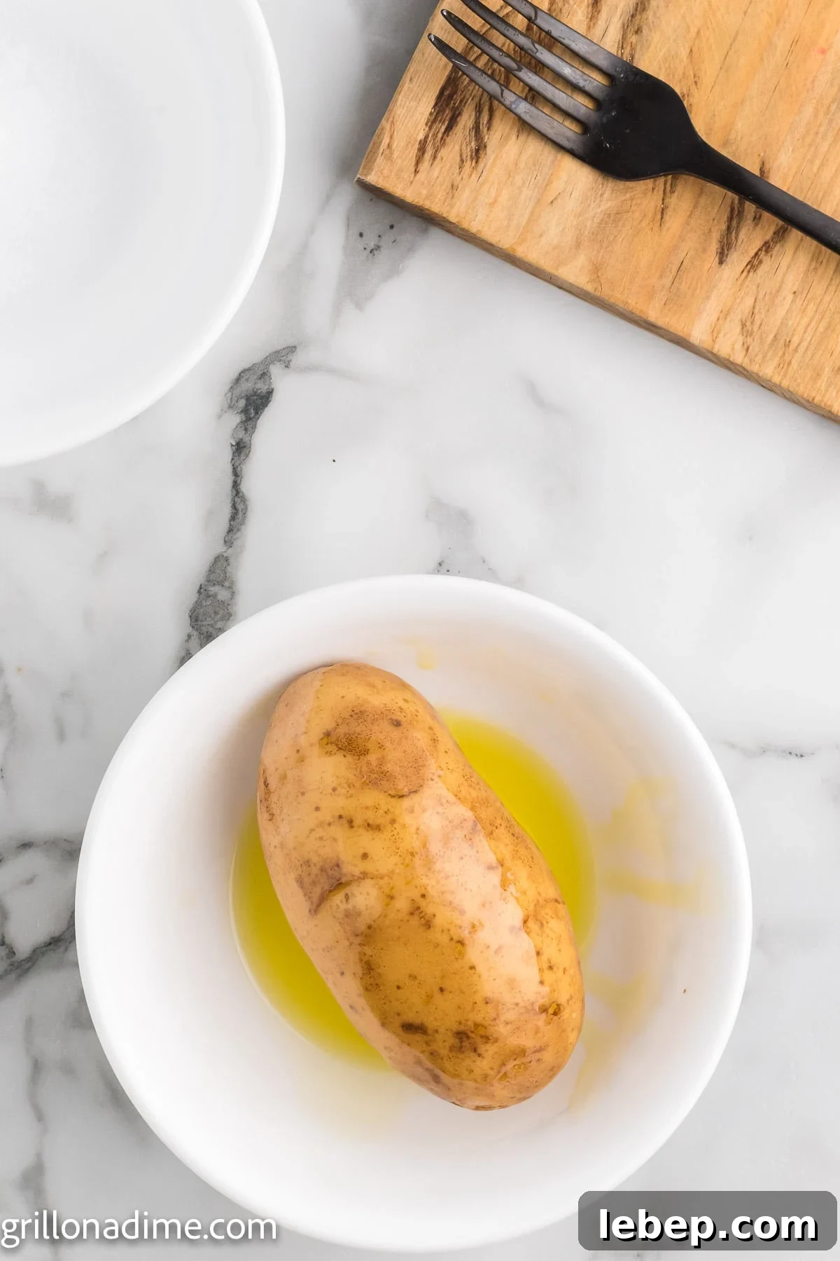 Smoked Baked Potatoes Recipe: Crispy Skin, Smoky Flavor 5 Bake potatoes being covered in a oil in a bowl
