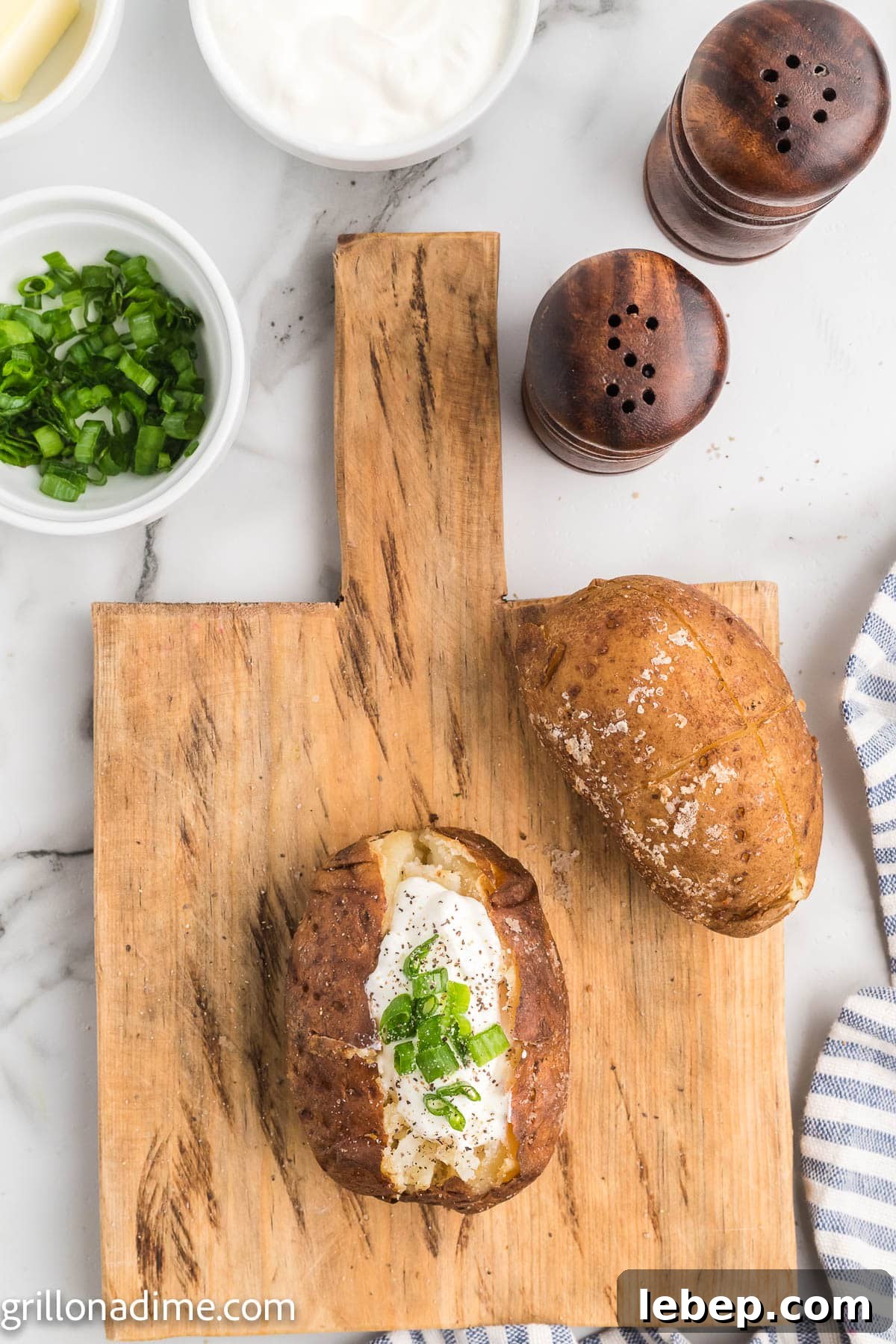 Smoked Baked Potatoes Recipe: Crispy Skin, Smoky Flavor 7 Smoked baked potatoes on a wooden board topped with sour cream and chives