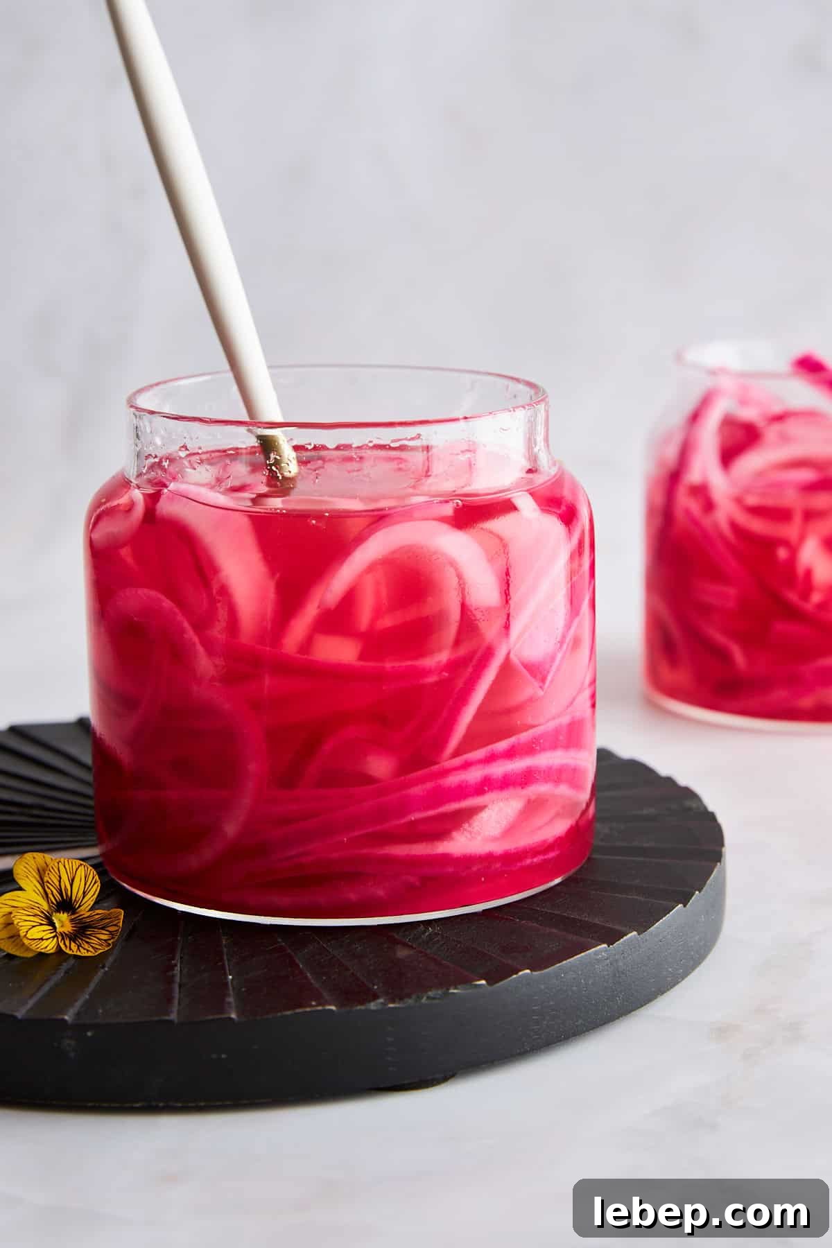 A jar of pickled red onions with a fork sticking out. 
