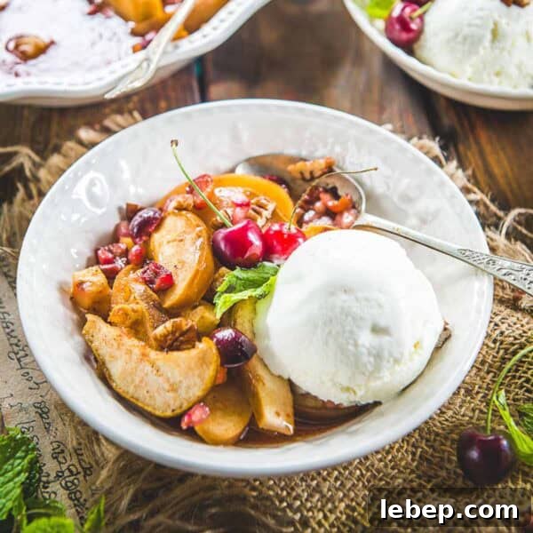 Spiced fruit bake served in a bowl with a scoop of vanilla ice cream.