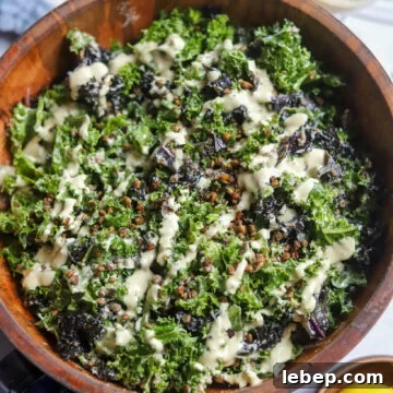 overhead view of a wooden bowl with homemade vegan caesar with lentils, tofu dressing, and massaged kale.