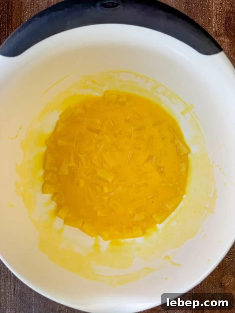 Instant vanilla pudding setting up in pineapple tidbits with natural juice in a white mixing bowl.