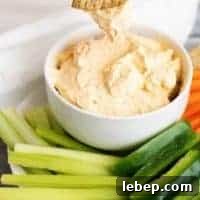 Creamy Buffalo Chicken Dip Recipe for Parties and Game Day 7 Cracker being dipped into buffalo cheese dip.
