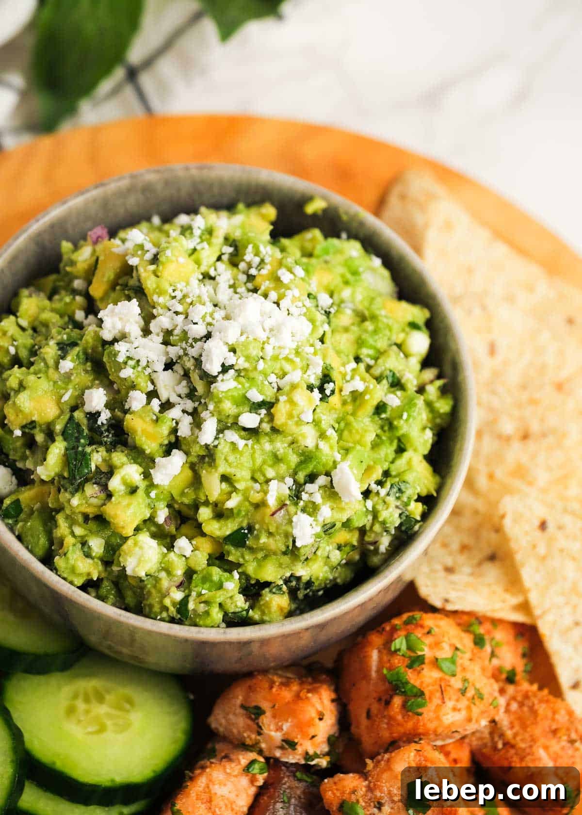 Creamy Avocado and Feta Dip Recipe for Parties and Snacks 2 A bowl of avocado feta dip with chips, vegetables and salmon