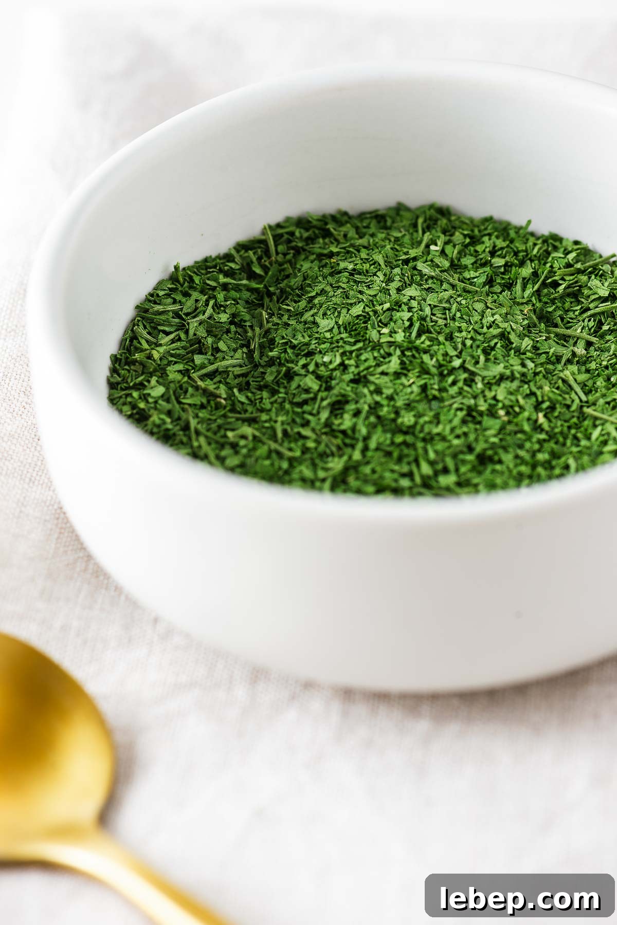 Drying Parsley in the Oven: Quick Guide for Flavorful Dried Herbs 2 A small white ceramic bowl with oven dried parsley.