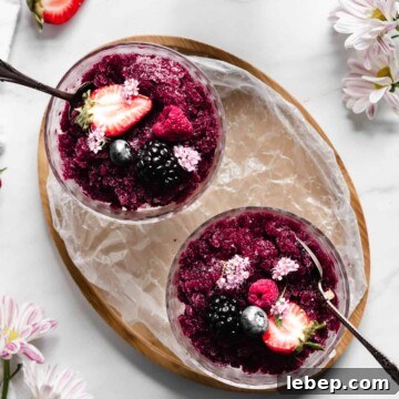 An overhead shot of two coupes with granita and topped with berries.