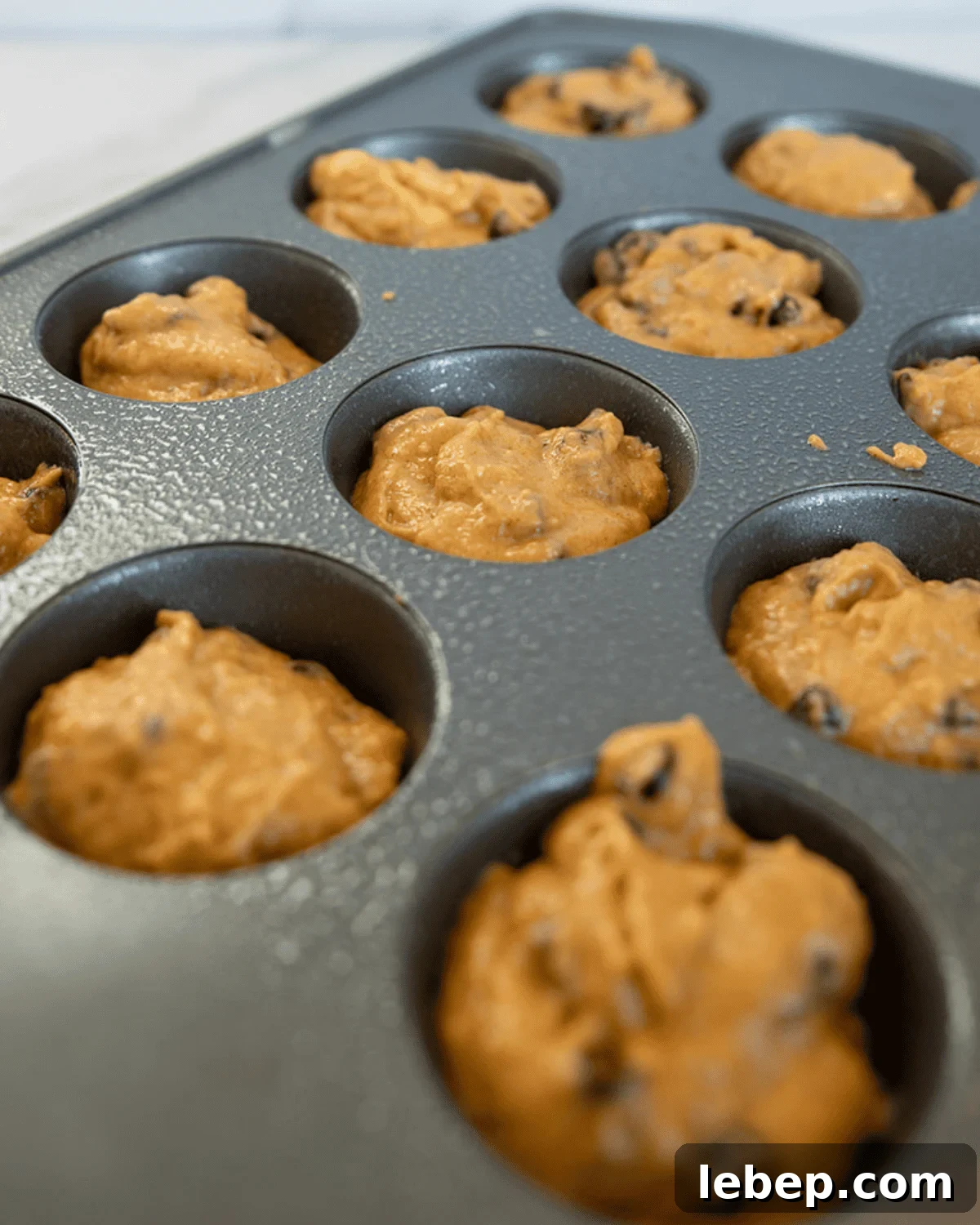 Large-Batch Pumpkin Chocolate Chip Muffins Recipe 5 dough in muffin tins ready to bake