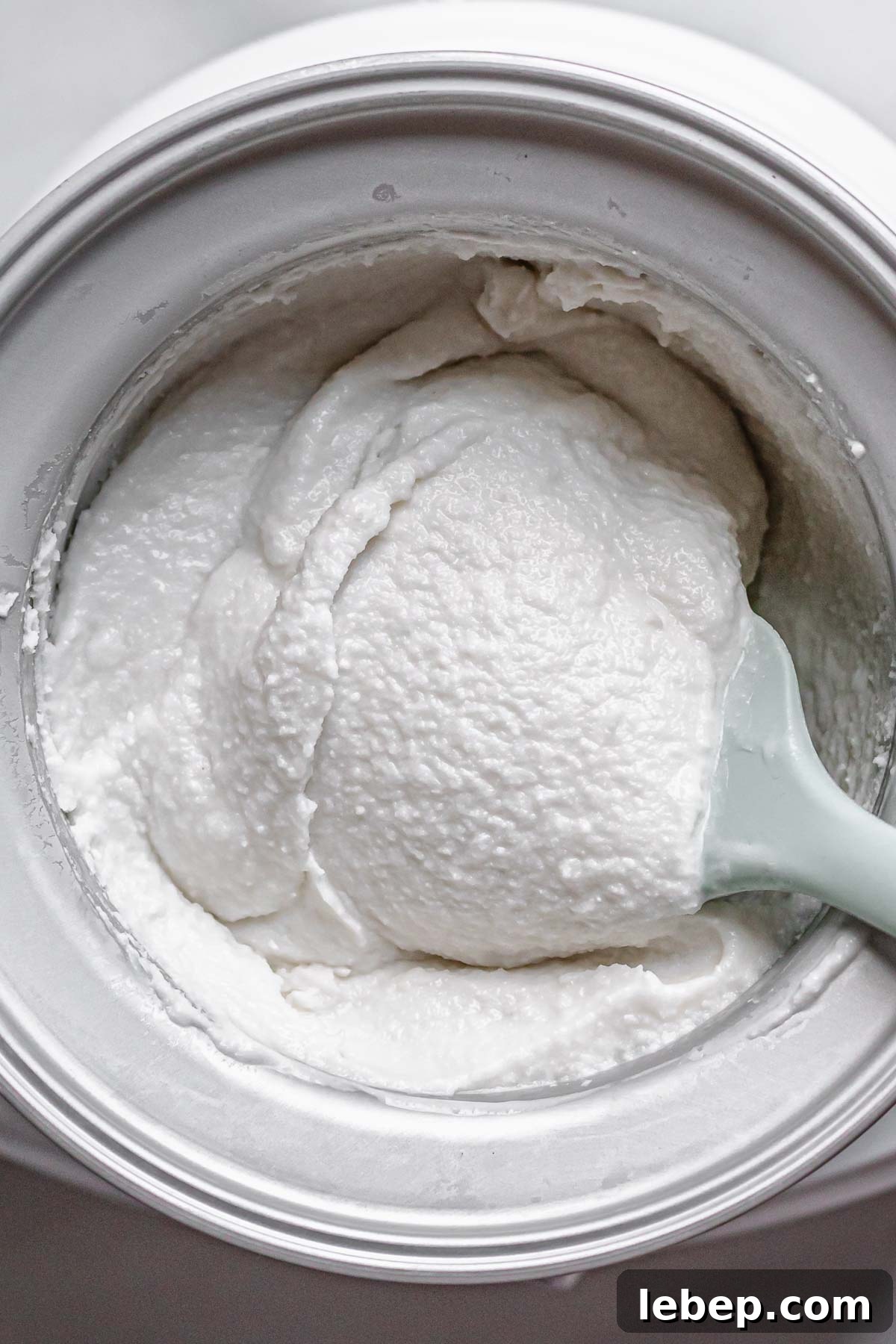 Creamy Coconut Sorbet Recipe: Refreshing Tropical Dessert 8 A spatula holds up the coconut sorbet to show the texture.