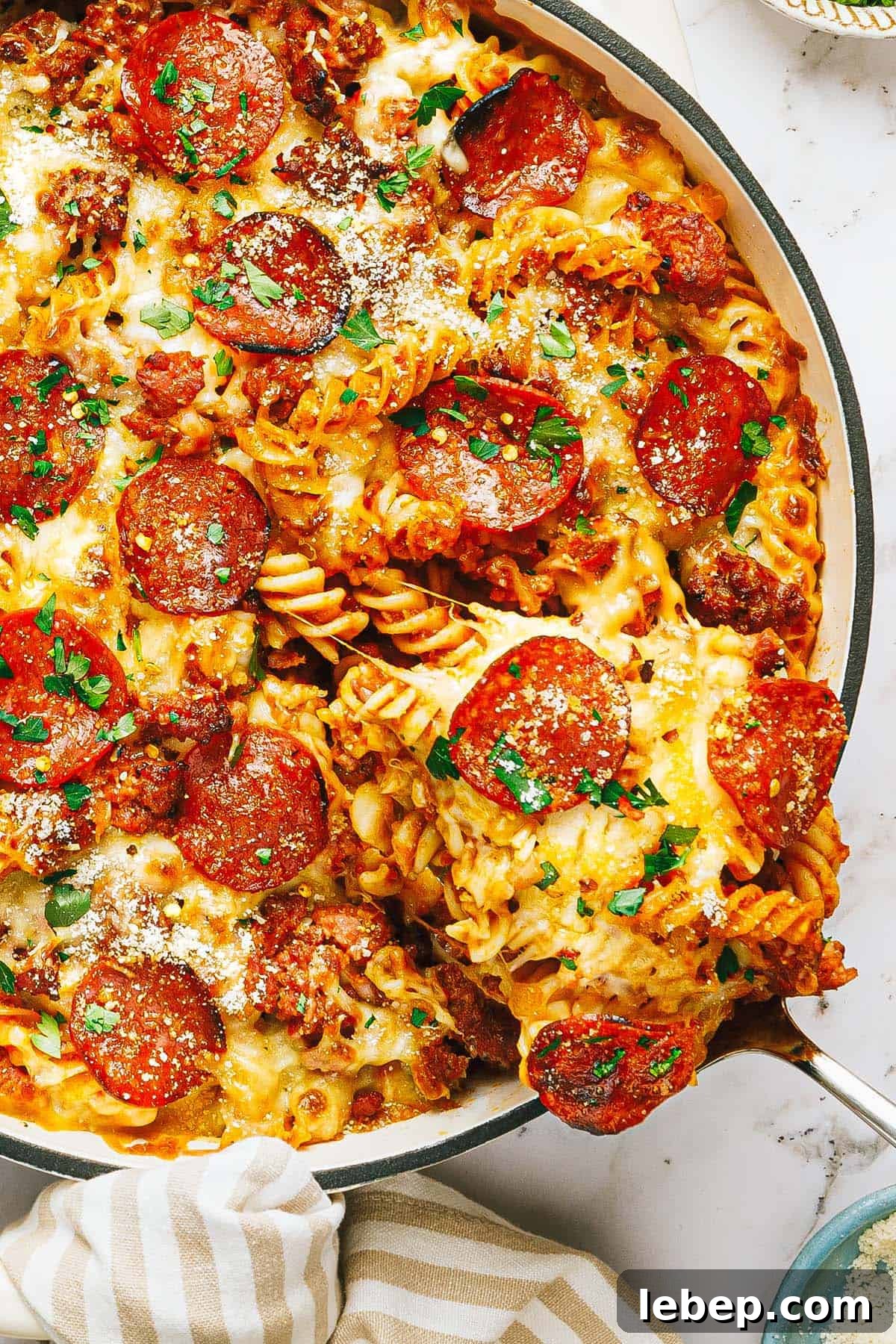 Pepperoni & Sausage Pizza Pasta Bake Recipe 2 Large pan filled with pepperoni pizza pasta garnished with parsley.