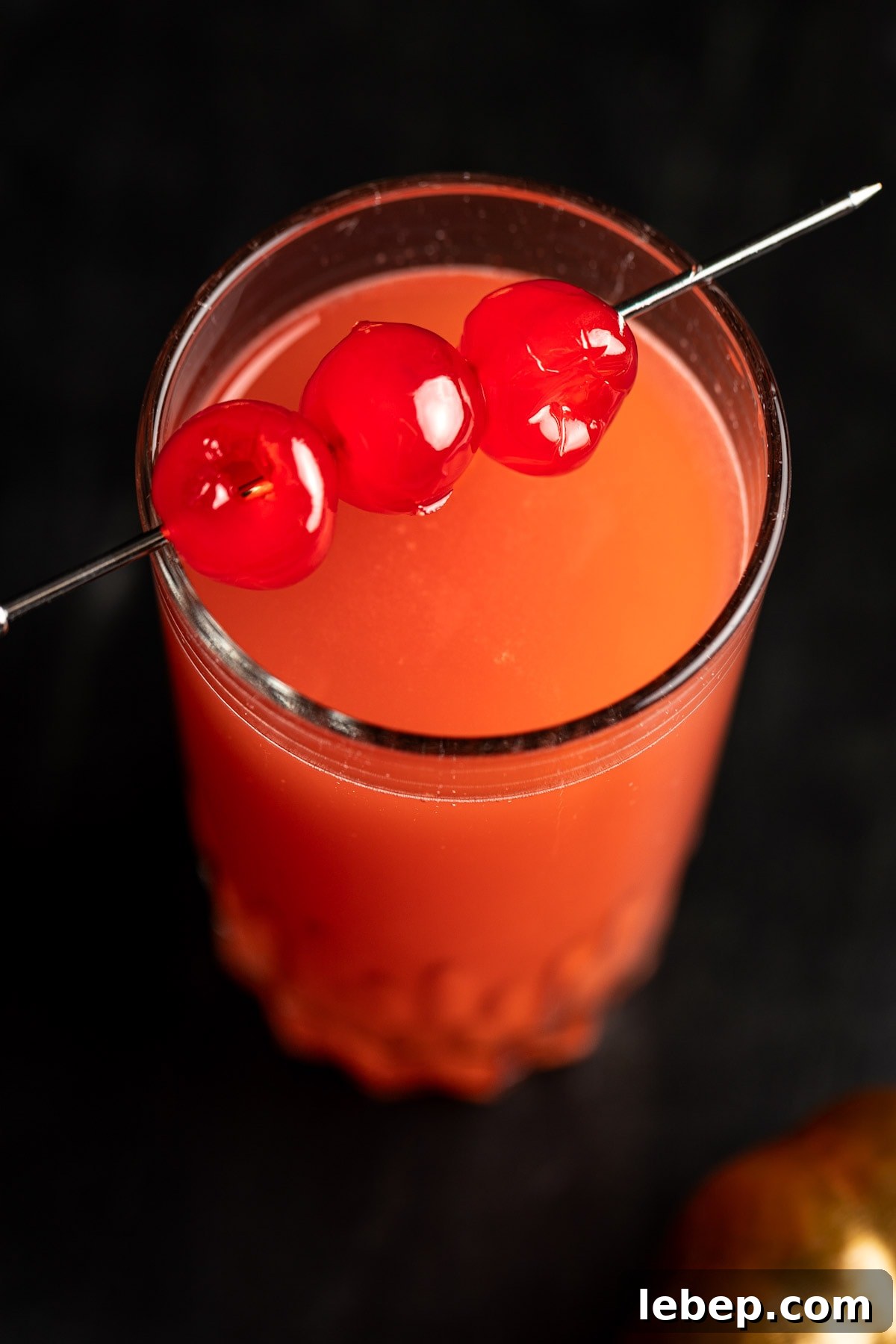 How to Make a Red Devil Cocktail: Recipe & Serving Tips 3 Overhead view of a red devil drink garnished with maraschino cherries.