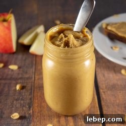 How to Make Nut Butter at Home: Complete Step-by-Step Guide 4 a jar of peanut butter in front of a sliced apple and plate
