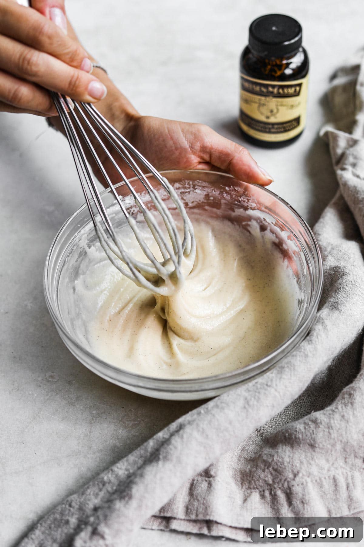 Hand whisking easy vanilla bean icing for muffins, cakes, cinnamon rolls, scones, and more.