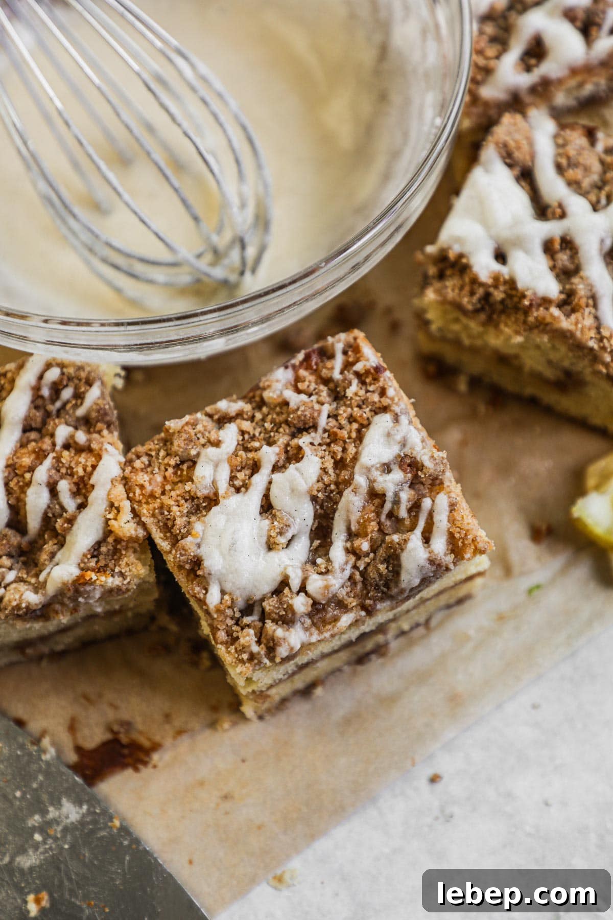 Easy classic vanilla bean icing drizzled on a slice of coffee cake.