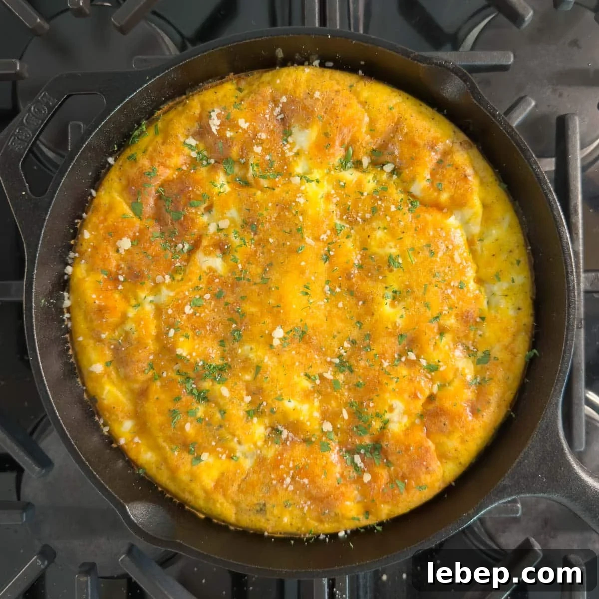 Ham and cheese frittata in a cast iron skillet on the stovetop.