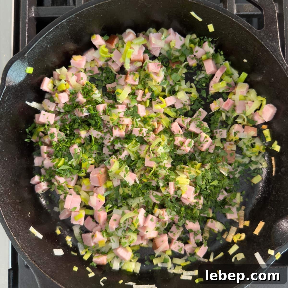 Building layers of a frittata vegetables base now adding green chopped parsley.