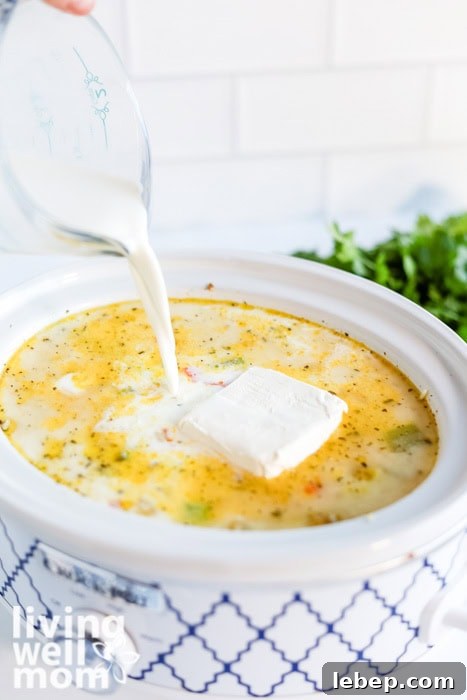 Creamy Slow Cooker Wild Rice and Chicken Soup Recipe 9 Pouring milk into creamy chicken and wild rice soup in the slow cooker