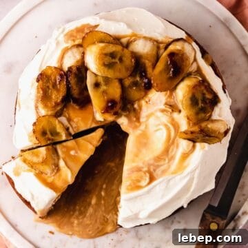 Decadent Banoffee Cake Recipe with Caramelized Bananas 15 cutting a slice of cake with bananas and caramel sauce