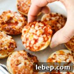 Air Fryer Bagel Bites: Quick Crispy Snack in Minutes 8 Hand holding a pizza bagel