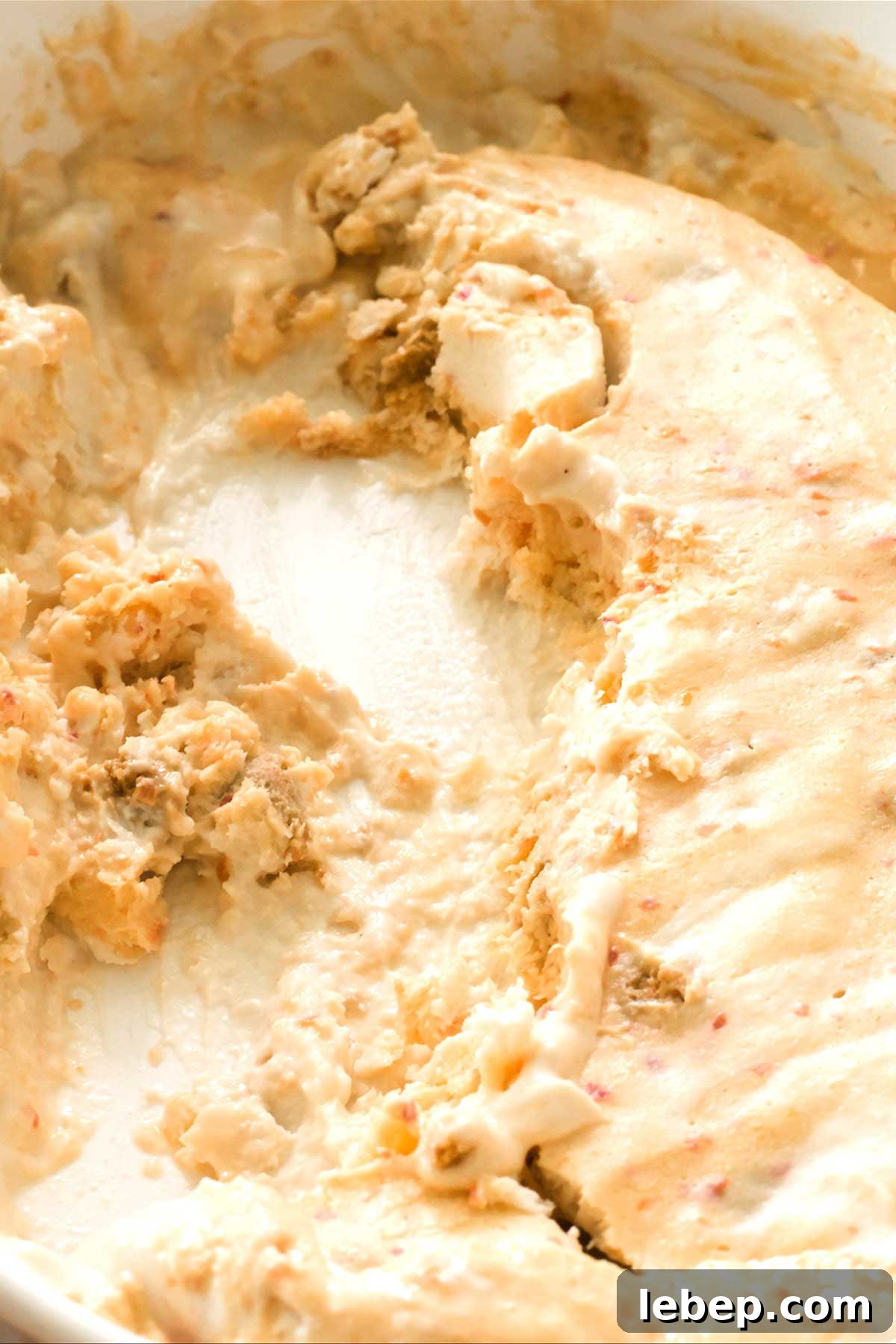 A close-up of the peach pie cottage cheese ice cream scooped out of the shallow dish.